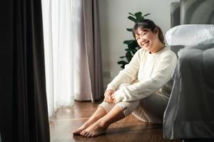 contento donna seduta nel il Camera da letto nel il mattina. foto