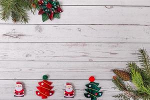 Natale decorazione con abete rami, Natale albero pendente, Santa Claus decorazione e rosso frutti di bosco su un' di legno sfondo foto