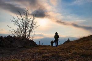 ragazza con sua cane nel il montagna strada su un' religioso pellegrinaggio foto