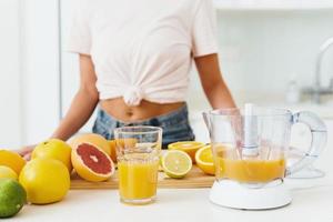 bicchiere di arancia succo e agrume spremiagrumi su il cucina tavolo foto