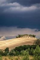 toscana, italia, 2020 - casa su una collina sotto un cielo tempestoso foto