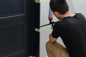 il uso di montaggio schiuma con un' spray pistola nel costruzione lavori, installazione di interno porte. foto