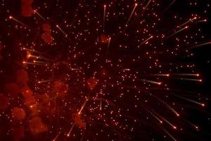 saluto. luminosa, rosso spruzzi di fuochi d'artificio nel il buio cielo. foto