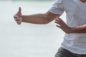 giovane uomo praticante tradizionale tai chi chuan, tai ji e qi gong nel il parco per sano, tradizionale Cinese marziale arti concetto su naturale sfondo . foto