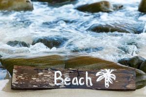 di legno cartello con lettering su il spiaggia foto