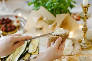 donna fabbricazione un' Sandwich a il festivo tavolo. foto