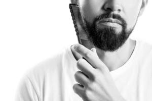 uomo pettinatura il suo barba su bianca sfondo foto