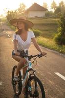 donna è equitazione bicicletta di stretto nazione strada foto