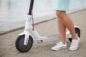 femmina gambe su il elettrico scooter foto