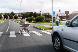 negligente madre A proposito di di Telefono mentre sua bambino carrozzina lanciato su su il strada foto