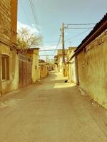 stretto strada, corsia, tunnel con vecchio case, edifici su il lati nel un' povero la zona di il città, baraccopoli. verticale foto