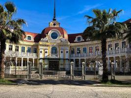 bellissimo vecchio classico antico nazione costruzione, dimora, villa, Casa con un' rosso piastrella tetto con un' guglia con verde palma alberi nel un' caldo tropicale nazione foto