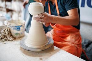 mani di giovane vasaio, era prodotta su gamma mani di un' vasaio abilmente fabbricazione un' pentola di bianca argilla. foto
