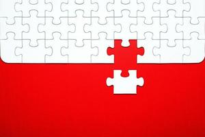 bianca puzzle pezzi su un' rosso sfondo separato foto