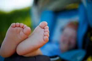 carino, divertente dolce tacchi di un' bambino contro il sfondo di un' dire bugie nel un' passeggino foto