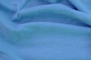 il struttura di il tessuto nel blu colore. Materiale per fabbricazione camicie e camicette foto
