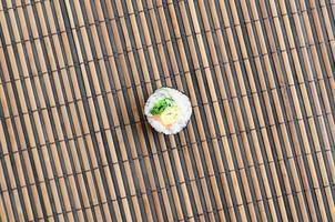 Sushi rotolo menzogna su un' bambù cannuccia servire stuoia. tradizionale asiatico cibo. superiore Visualizza. piatto posare minimalismo tiro con copia spazio foto