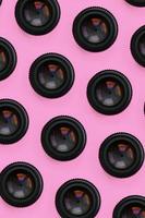 un' pochi telecamera lenti a contatto con un' chiuso apertura menzogna su struttura sfondo di moda pastello rosa colore carta nel minimo concetto. astratto di moda modello foto