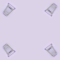 modello di molti piccolo shopping carrelli su un' viola sfondo. minimalismo piatto posare superiore Visualizza foto