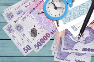 50000 rumeno leu fatture e allarme orologio con penna e buste. imposta stagione concetto, pagamento Scadenza per credito o prestito. finanziario operazioni utilizzando postale servizio foto