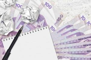 100 filippino piso fatture e palle di spiegazzato carta con vuoto bloc notes. cattivo idee o Di meno di ispirazione concetto. ricerca idee per investimento foto