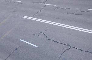 danneggiato cattivo asfalto strada con buche. toppa riparazione di asfalto foto