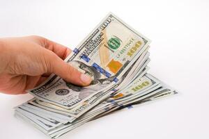 mano umana che tiene banconote in dollari americani su sfondo bianco foto