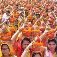 nuova delhi, india 03 aprile 2022 - donne con kalash sulla testa durante il tempio di jagannath mangal kalash yatra, devoti indù indiani portano pentole di terracotta contenenti acqua sacra con una noce di cocco in cima foto