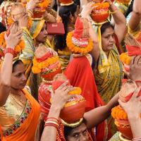 nuova delhi, india 03 aprile 2022 - donne con kalash sulla testa durante il tempio di jagannath mangal kalash yatra, devoti indù indiani portano pentole di terracotta contenenti acqua sacra con una noce di cocco in cima foto