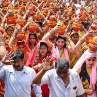 nuova delhi, india 03 aprile 2022 - donne con kalash sulla testa durante il tempio di jagannath mangal kalash yatra, devoti indù indiani portano pentole di terracotta contenenti acqua sacra con una noce di cocco in cima foto