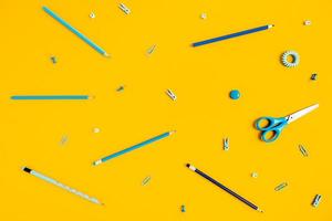 sfondo giallo con penne e matite per la pubblicità scolastica. foto