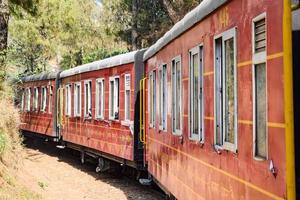 trenino che si muove sui pendii delle montagne, bella vista, un lato della montagna, un lato della valle che si muove sulla ferrovia verso la collina, tra il verde della foresta naturale. trenino da kalka a shimla in india, treno indiano foto