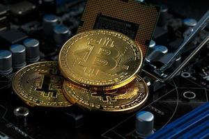 d'oro bitcoin criptovaluta su computer circuito tavola processore. macro sparo. foto