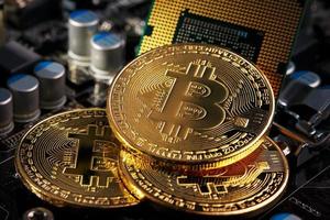 d'oro bitcoin criptovaluta su computer circuito tavola processore. macro sparo. foto