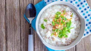 superiore Visualizza di prima colazione menù, bollito riso con caldo tritato Maiale e servito su di legno sfondo. foto