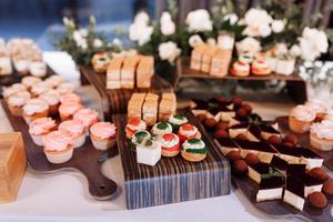 caramella bar decorato di delizioso dolce buffet con cupcakes, bignè, dolcezza e fiori, e altro dolci, caramella, dolce tavolo per un' nozze o compleanno festa. foto
