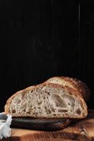 fresco artigiano lievito pane su un' taglio tavola. avvicinamento, verticale telaio con copia spazio foto