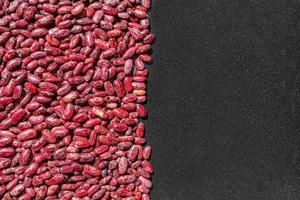 rosso fagioli su un' nero padella sfondo, nutriente verdura proteina, superiore Visualizza con copia spazio per testo. idea per un' bandiera o Prodotto annuncio, sfondo per un articolo descrivendo un' ricetta o dieta foto