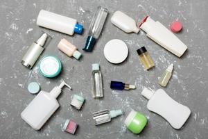 gruppo di plastica cura del corpo bottiglia piatto posare composizione con cosmetico prodotti su blu sfondo vuoto spazio per voi design. impostato di bianca cosmetico contenitori, superiore Visualizza con copia spazio foto