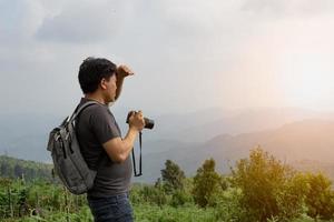 un' sian uomo con il suo zaino e telecamera è viaggio solo e Guarda a lontano un' modo, natura viaggio e ambiente concetto, copia spazio per individuale testo foto