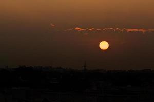 sole che tramonta in un cielo scuro foto