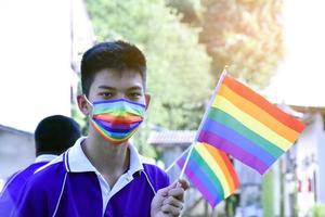 ritratto asiatico giovane ragazzo detiene arcobaleno bandiera, lgbt simbolo, nel mani mentre unendo il suo lgbt attività a scuola, concetto per lgbt Comunità celebrazione nel orgoglio mese, giugno, 2023, in giro il mondo. foto