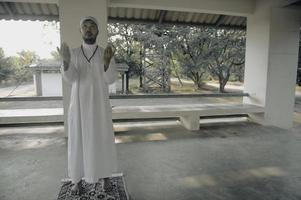 giovane asiatico musulmano uomo preghiere su tramonto, ramadan Festival concetto foto