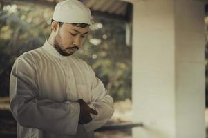 giovane asiatico musulmano uomo preghiere su tramonto, ramadan Festival concetto foto