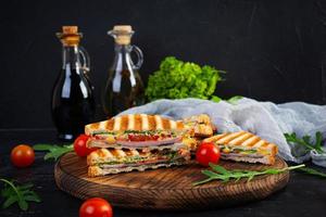 Sandwich con prosciutto, formaggio, mostarda foglie, pomodori e cipolla. gustoso club panini foto