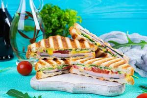 Sandwich con prosciutto, formaggio, mostarda foglie, pomodori e cipolla. gustoso club panini