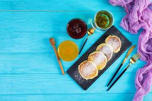 delizioso fatti in casa syrniki con fragola marmellata e Miele. tradizionale russo piatto sirniki. superiore Visualizza foto