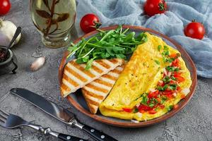 fritte frittata con pomodori, cipolla e erbe aromatiche. delizioso prima colazione con uova e toast foto