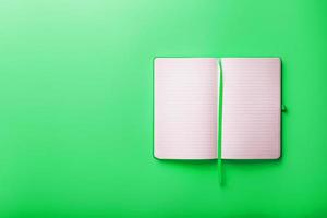 Aperto taccuino, un' libro con vuoto e vuoto pagine su un' verde sfondo, superiore Visualizza. foto