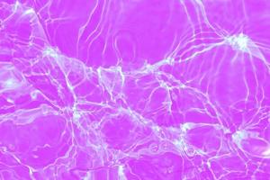 defocus sfocato trasparente viola colorato chiaro calma acqua superficie struttura con spruzzi e bolle. di moda astratto natura sfondo. acqua onde nel luce del sole con copia spazio. rosa acquerello brillare foto